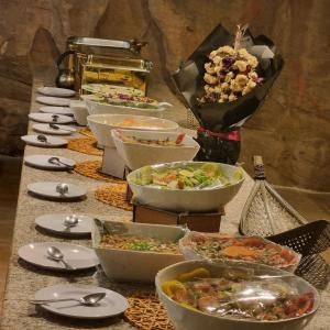 a buffet of bowls of food on a table at Desert Hello Camp in Wadi Rum