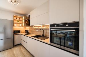 a kitchen with white cabinets and a stainless steel refrigerator at OLEA Holiday Home Benkovac-private pool,garden and parking in Šopot