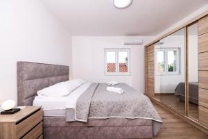 a white bedroom with a bed and a mirror at OLEA Holiday Home Benkovac-private pool,garden and parking in Šopot +42 photos