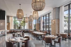 a restaurant with tables and chairs and large windows at Hyatt Centric Downtown Nashville in Nashville