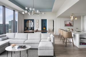 a living room with a white couch and a kitchen at Hyatt Centric Downtown Nashville in Nashville