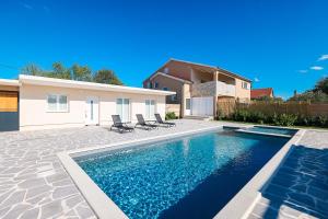 a swimming pool in front of a house at OLEA Holiday Home Benkovac-private pool,garden and parking in Šopot