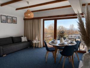 a living room with a couch and a table with chairs at Apartamenty Na Fali in Jastarnia