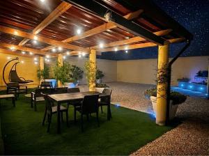 a patio with a table and chairs and lights at Costa Ovest Apartment 3 in Nurachi