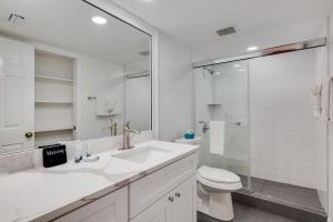a white bathroom with a sink and a toilet at Beach Villa 2323 - Captiva One Bedroom Deluxe Beachfront Residence in Captiva +9 photos