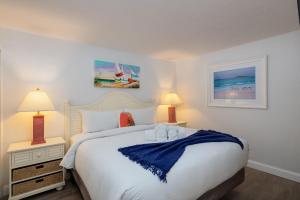 a bedroom with a large white bed with two lamps at Beach Villa 2323 - Captiva One Bedroom Deluxe Beachfront Residence in Captiva