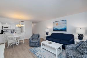 a living room with a blue couch and a table at Beach Villa 2323 - Captiva One Bedroom Deluxe Beachfront Residence in Captiva