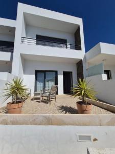 a white house with plants in front of it at Ribavilla Surf House in Santo Isidoro