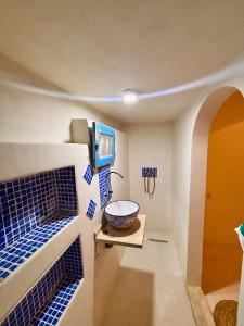 a bathroom with blue tiles on the walls and a sink at Dar Hallouma - WostelDjerba community in Djerba
