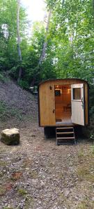 a small cabin in the woods with a table in it at Maringotka pod hvozdem in Spešov