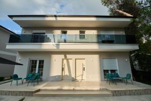 a house with a balcony with chairs in front of it at Blue Golem Durres Albania in Golem