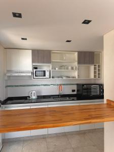 a kitchen with stainless steel appliances and wooden counters at Zelena Voda in Villa Gesell