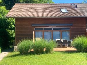a house with a table and chairs in front of it at Tu Casa Chiemsee Ferienhaus in Gstadt am Chiemsee