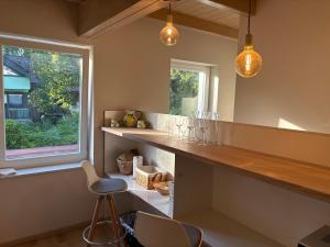 a kitchen with a counter and a window with glasses at Fűzfás Apartman in Siófok