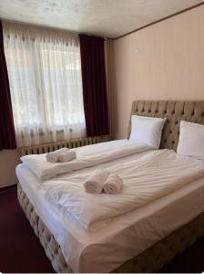 a bedroom with a large bed with towels on it at Guest House Скиора in Chepelare