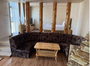 a living room with a leather couch and a table at Guest House Скиора in Chepelare