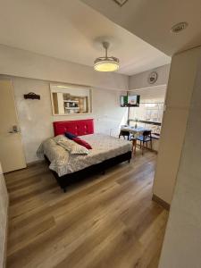 a bedroom with a bed with a red headboard and a table at Torre Obelisco - Apart 2 Amb en Av Corrientes, Buenos Aires, Argentina in Buenos Aires