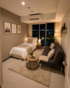 a bedroom with a bed and a couch and a table at Azure Urban Resort Residences by Value Suites in Manila
