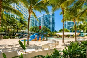 a playground at a resort with palm trees and buildings at Azure Urban Resort Residences by Value Suites in Manila