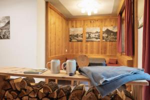 a room with a table and a pile of logs at Haus Alpenkönig Exclusive Apartments near Stubai Glacier in Neustift im Stubaital