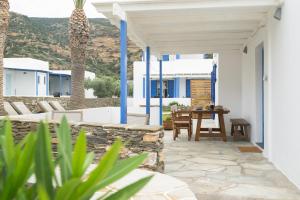 a patio with a table and chairs on a house at KALYPSO ACCOMMODATION SIFNOS in Vathi