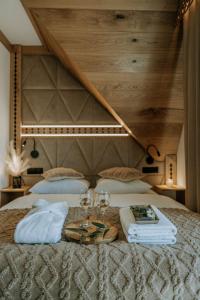 a bed with two glasses and a tray of wine glasses at Willa Regina I Resort & SPA in Zakopane
