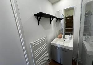 a white bathroom with a sink and a mirror at Studio Quartier Amiens in Amiens