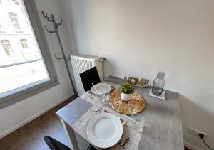 a table with two glasses and a vase on it at Studio Quartier Amiens in Amiens