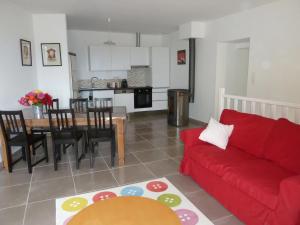 a living room with a red couch and a table at La Roseraie des Côtes - Piscine in Vinsobres