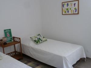 a room with two beds and a night stand with a table at La Roseraie des Côtes - Piscine in Vinsobres