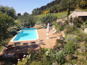 a pool in a garden with chairs and a house at La Roseraie des Côtes - Piscine in Vinsobres