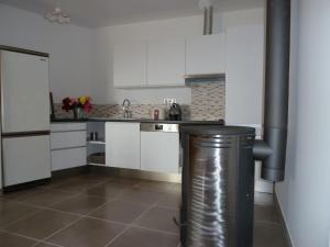 a kitchen with white cabinets and a trash can at La Roseraie des Côtes - Piscine in Vinsobres +9 photos
