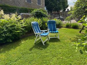 two chairs sitting in the grass in a garden at Chez Marraine in Nassogne