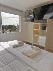 a bedroom with a large white bed with towels on it at Zelena Voda in Villa Gesell +46 photos