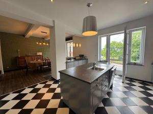a kitchen with a sink and a checkered floor at Chez Marraine in Nassogne