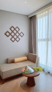 a living room with a couch and a table at APEC Mandala Mũi Né Official - Diễm Phạm Travel in Phan Thiet