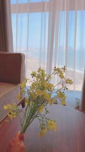 a vase of yellow flowers sitting on a table at APEC Mandala Mũi Né Official - Diễm Phạm Travel in Phan Thiet