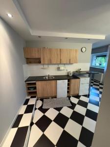 a kitchen with a black and white checkered floor at Hutnicza 54 in Poznań