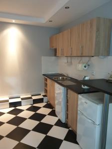 a kitchen with a black and white checkered floor at Hutnicza 54 in Poznań