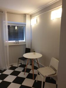 a table and chairs in a room with a checkered floor at Hutnicza 54 in Poznań