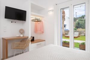 a bedroom with a bed and a tv on a wall at KALYPSO ACCOMMODATION SIFNOS in Vathi