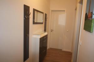 une salle de bain avec un lavabo et un miroir dans l'établissement Ferienwohnung Meeschendorf, à Fehmarn 32 autres photos