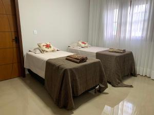 a room with two beds with blankets and a window at Casa 161 in Diamantina