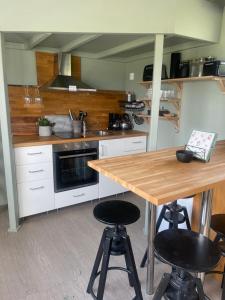 eine Küche mit einem Holztisch und zwei Barhockern in der Unterkunft Låbbyn15 in Årjäng