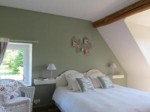 a bedroom with a white bed and a chair at Chambres d'Hôtes L’Échappée Belle in Saint-Brisson-sur-Loire +7 photos