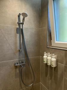 a shower in a bathroom with four bottles on the wall at Drymades Studio Apartment in Gjilek +39 photos