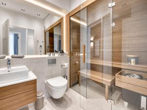 a bathroom with a toilet and a sink and a shower at Ferienwohnung Luxus Sonnensuite in der Strandvilla Charlotte Binz in Binz +11 photos