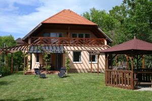 a house with a gazebo and chairs in the yard at La Perla Villa del Lago in Paloznak