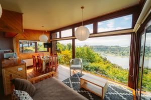 a living room with a view of a river at Tungulú - Hotel Boutique & Cabañas in Puerto Montt