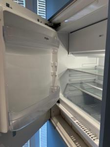 an empty refrigerator with its door open at Drymades Studio Apartment in Gjilek